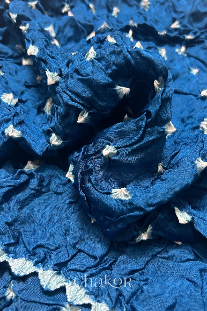 Close-up of indigo Bandhani modal fabric showing hand tie-dye Chakri motifs.
