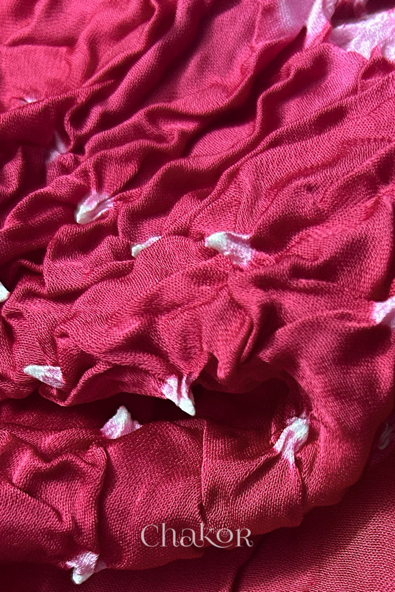 Close-up of pink Bandhani modal fabric showing hand tie-dye Chakri motifs.
