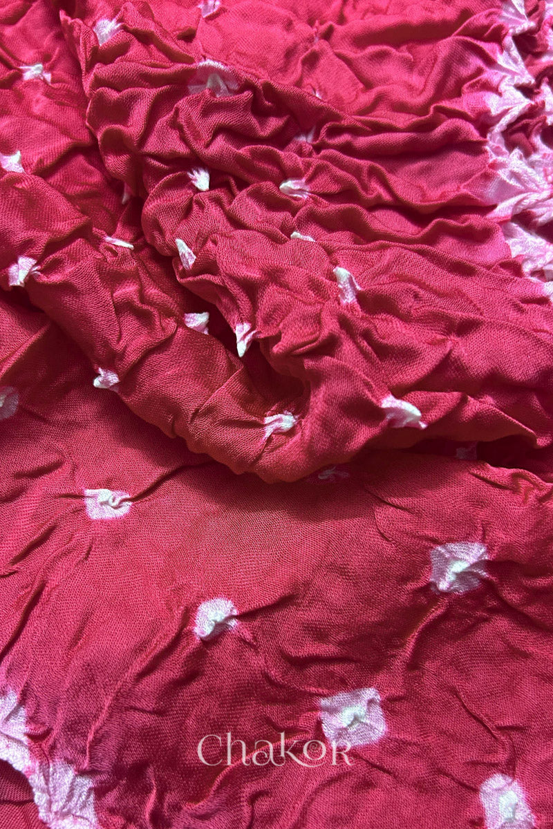 Close-up of pink Bandhani modal fabric showing hand tie-dye Chakri motifs.
