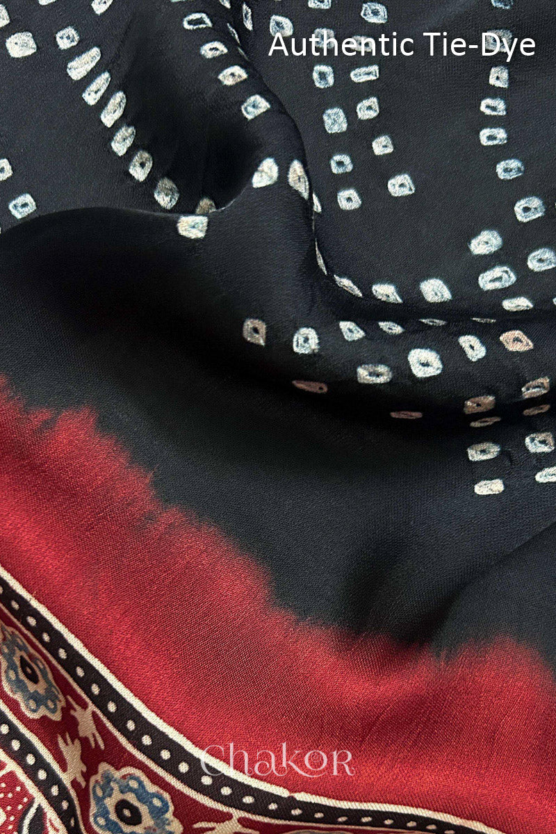 Red Hand tied Bandhani dots on modal stole with contrast ajrakh pallu detail showcasing fabric texture and softness.
