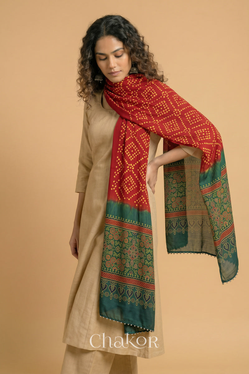  Red Bandhani modal stole styled across shoulders with detailed Green Ajrakh pallu and traditional hand tied pattern.
