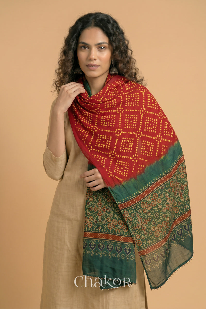  Red Bandhani modal stole styled across shoulders with detailed Green Ajrakh pallu and traditional hand tied pattern.
