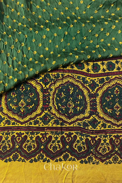 Hand tied  Green Bandhani patterns on modal stole with contrast  Mustard Ajrakh pallu detail.
