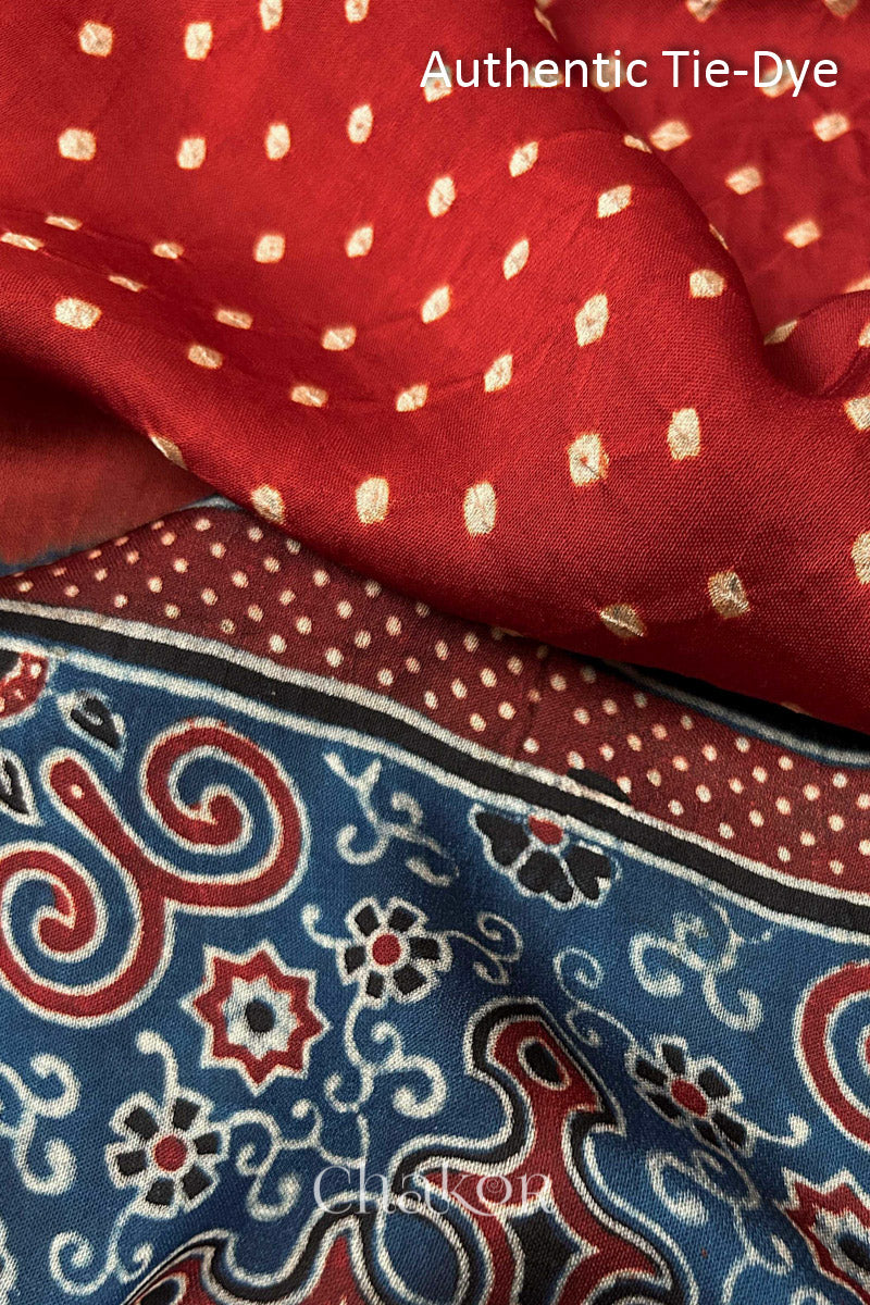 Red Hand tied Bandhani dots on modal stole with contrast ajrakh pallu detail showcasing fabric texture and softness.
