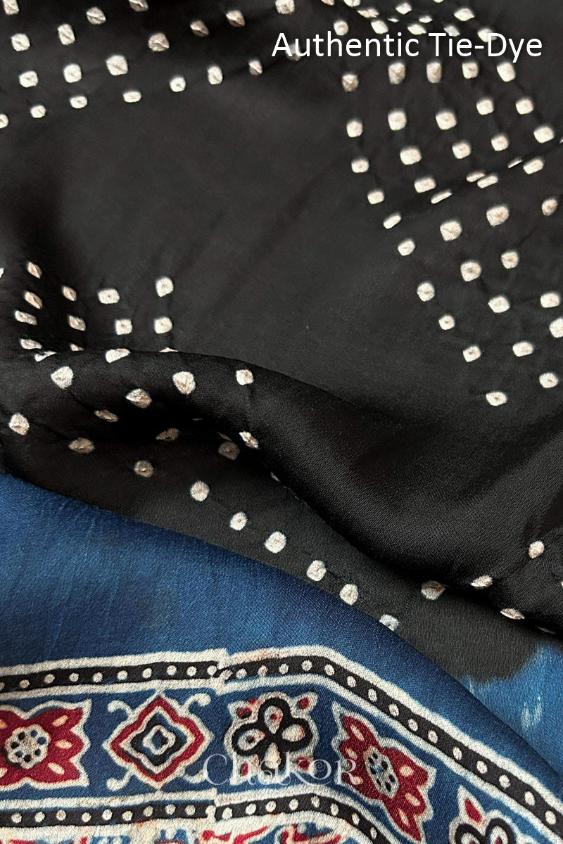 Black Hand tied Bandhani dots on modal stole with contrast ajrakh pallu detail showcasing fabric texture and softness.

