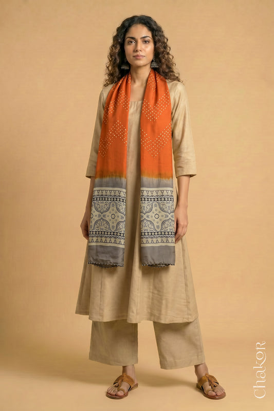 Handcrafted Bandhani Ajrakh modal stole draped on model with Orange Bandhani body and Taupe Beige Ajrakh pallu.
