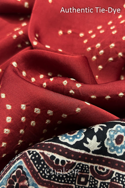 Red Hand tied Bandhani dots on modal stole with contrast ajrakh pallu detail showcasing fabric texture and softness.
