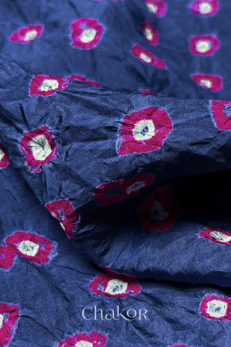 Close-up of Blue Grey fabric with Pink and white bandhani patterns, featuring texture and sheen of soft mulberry silk fabric.
