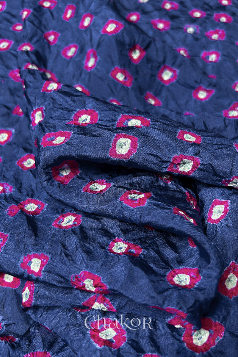 Close-up of Blue Grey fabric with Pink and white bandhani patterns, featuring texture and sheen of soft mulberry silk fabric.
