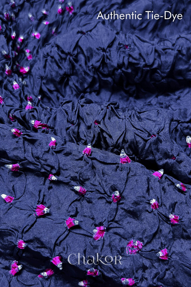 Close-up of Blue Grey mulberry silk fabric with Pink and white patterns, featuring texture of authentic bandhani patterns.
