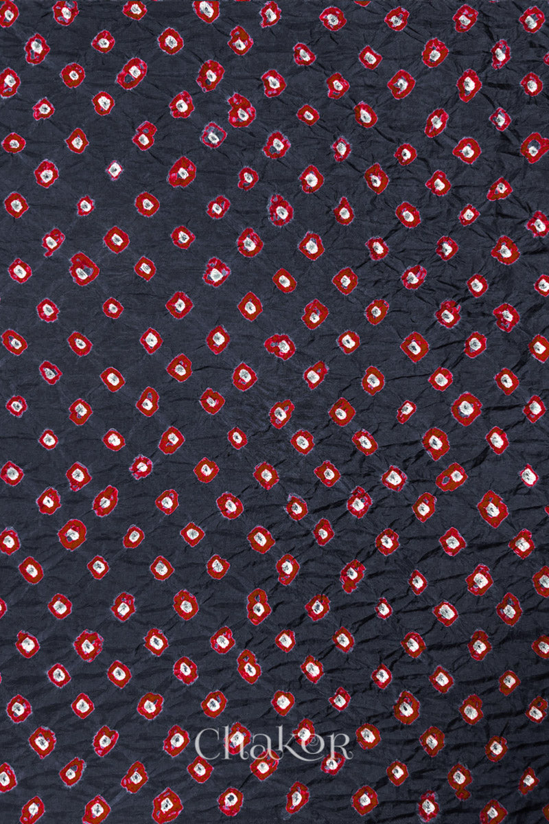 Charcoal Grey Mulberry silk fabric showcasing dual colour Red bandhani patterns and Chakor brand watermark.
