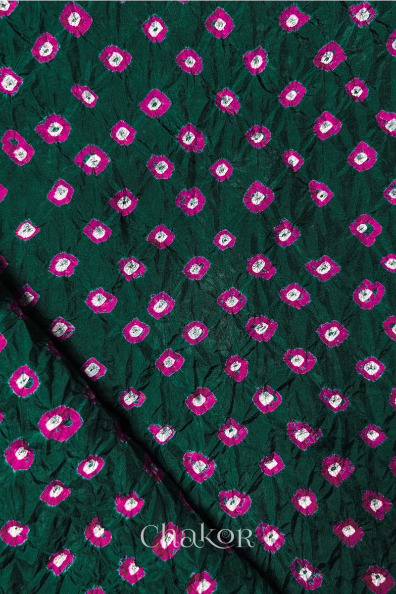 Dark Green Mulberry silk fabric showcasing dual colour Pink bandhani patterns with folded corner and Chakor brand watermark.
