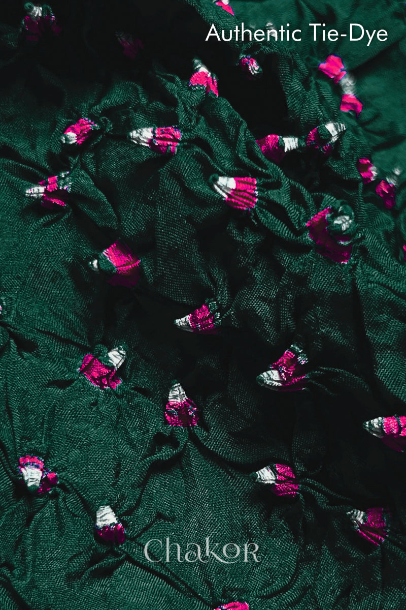 Close-up of Dark Green mulberry silk fabric with Pink and white patterns, featuring texture of authentic bandhani patterns.
