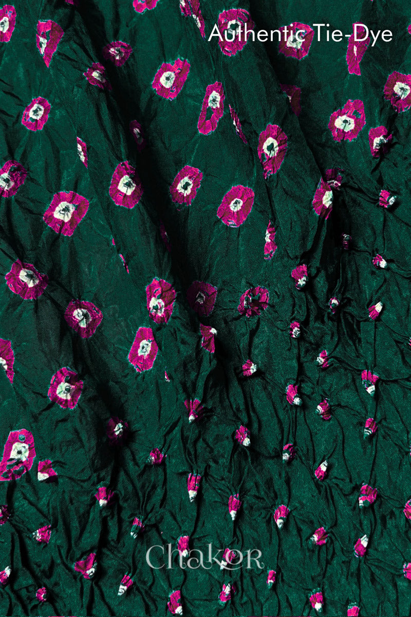 Close-up of Dark Green mulberry silk fabric with Pink and white patterns, featuring texture of authentic bandhani patterns.
