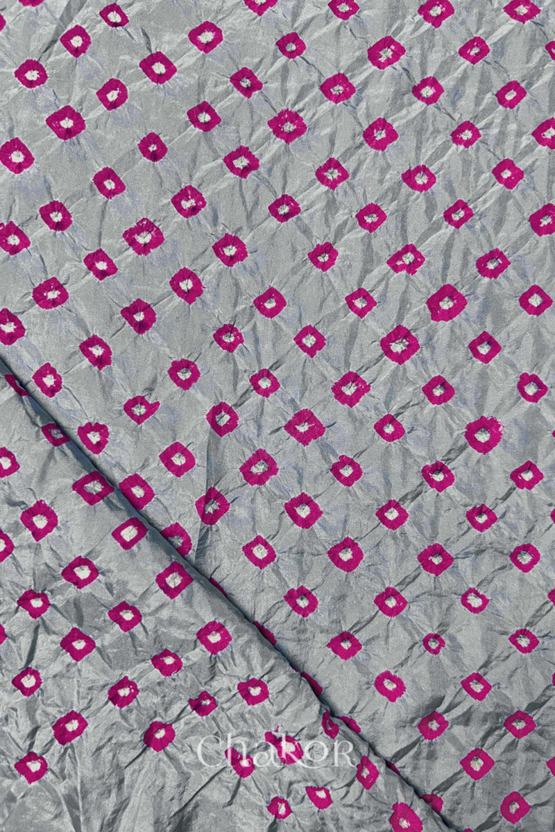 Light Grey Mulberry silk fabric showcasing dual colour Pink bandhani patterns with folded corner and Chakor brand watermark.
