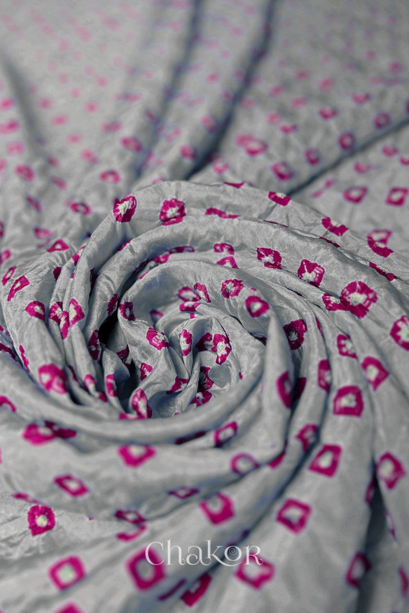 Light Grey Mulberry silk fabric with dual colour Pink bandhani dots, arranged in a swirling design  & Chakor brand watermark.

