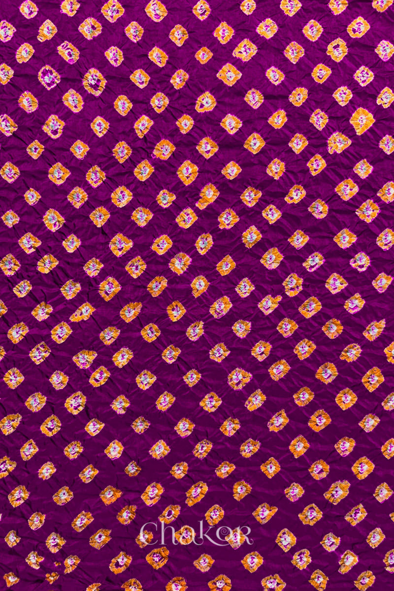 Magenta Mulberry silk fabric showcasing dual colour Yellow bandhani patterns and Chakor brand watermark.
