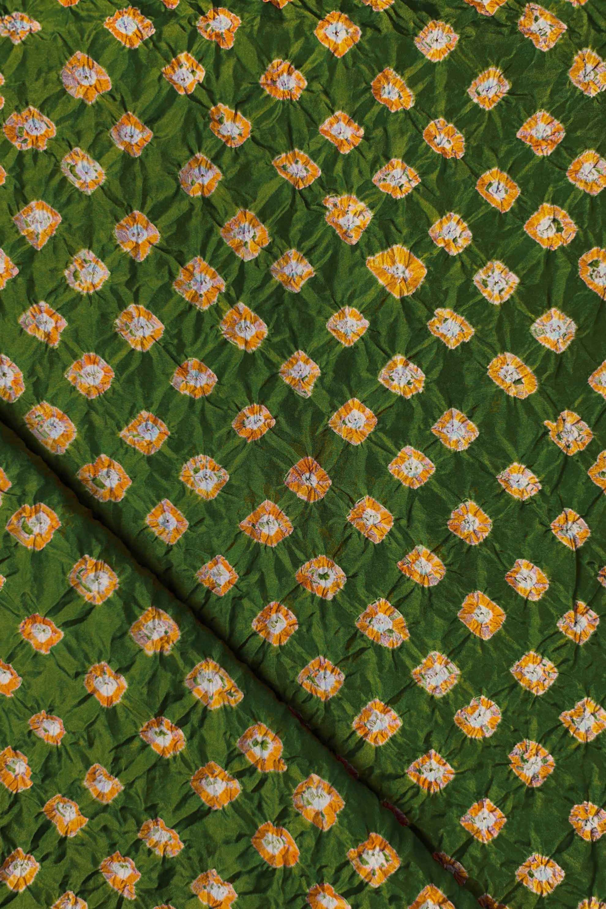 Mehendi Green Mulberry silk fabric showcasing dual colour Yellow bandhani patterns with folded corner and Chakor brand watermark.
