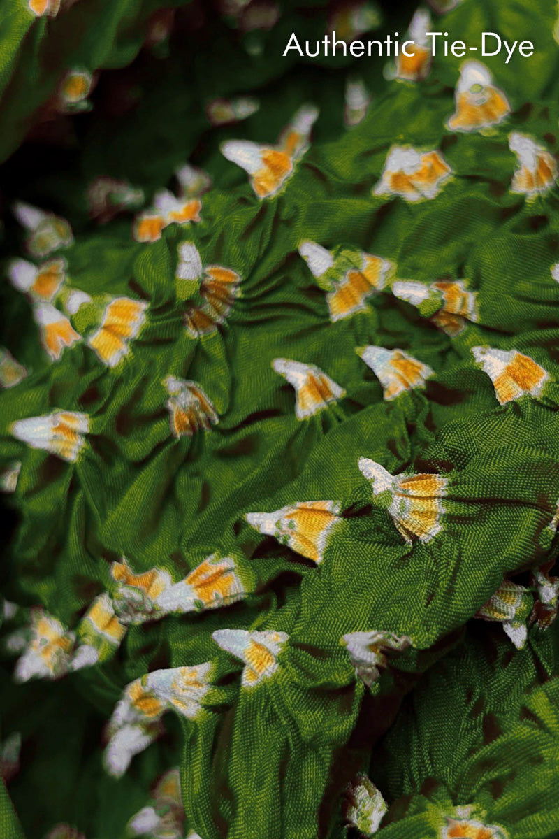Close-up of Mehendi Green fabric with Yellow and white bandhani patterns, featuring texture and sheen of soft mulberry silk fabric.
