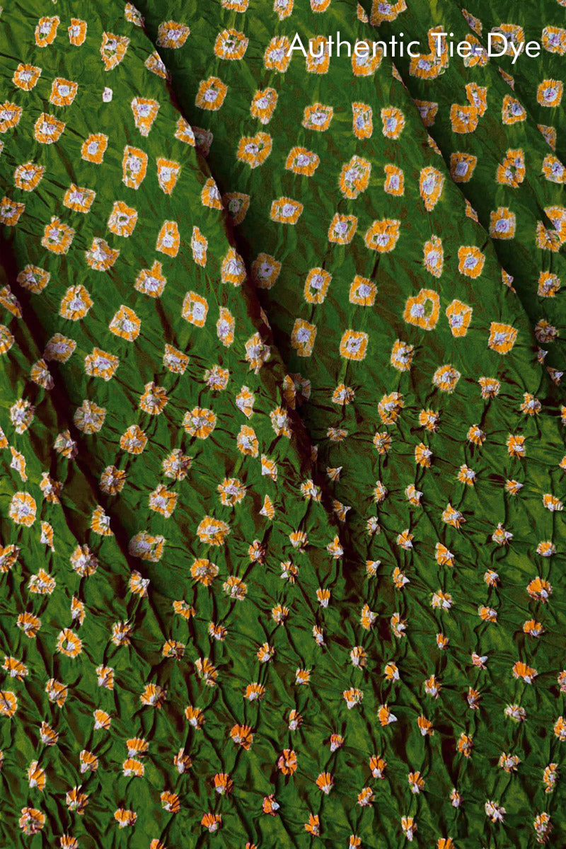 Close-up of Mehendi Green mulberry silk fabric with Yellow and white patterns, featuring texture of authentic bandhani patterns.
