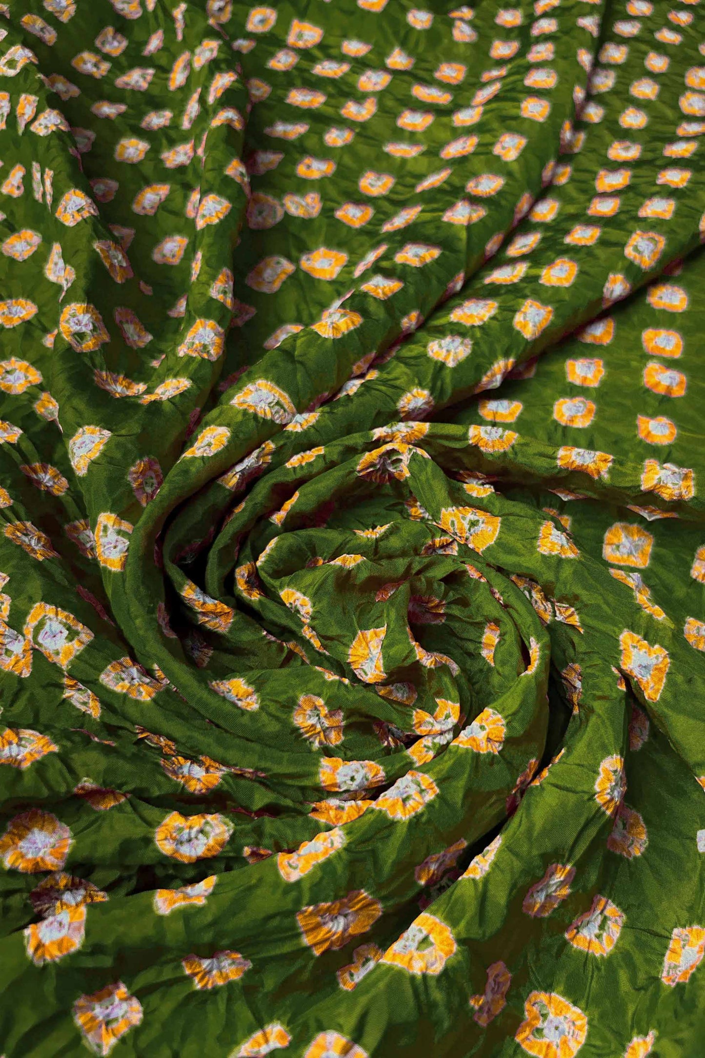 Mehendi Green Mulberry silk fabric with dual colour Yellow bandhani dots, arranged in a swirling design  & Chakor brand watermark.
