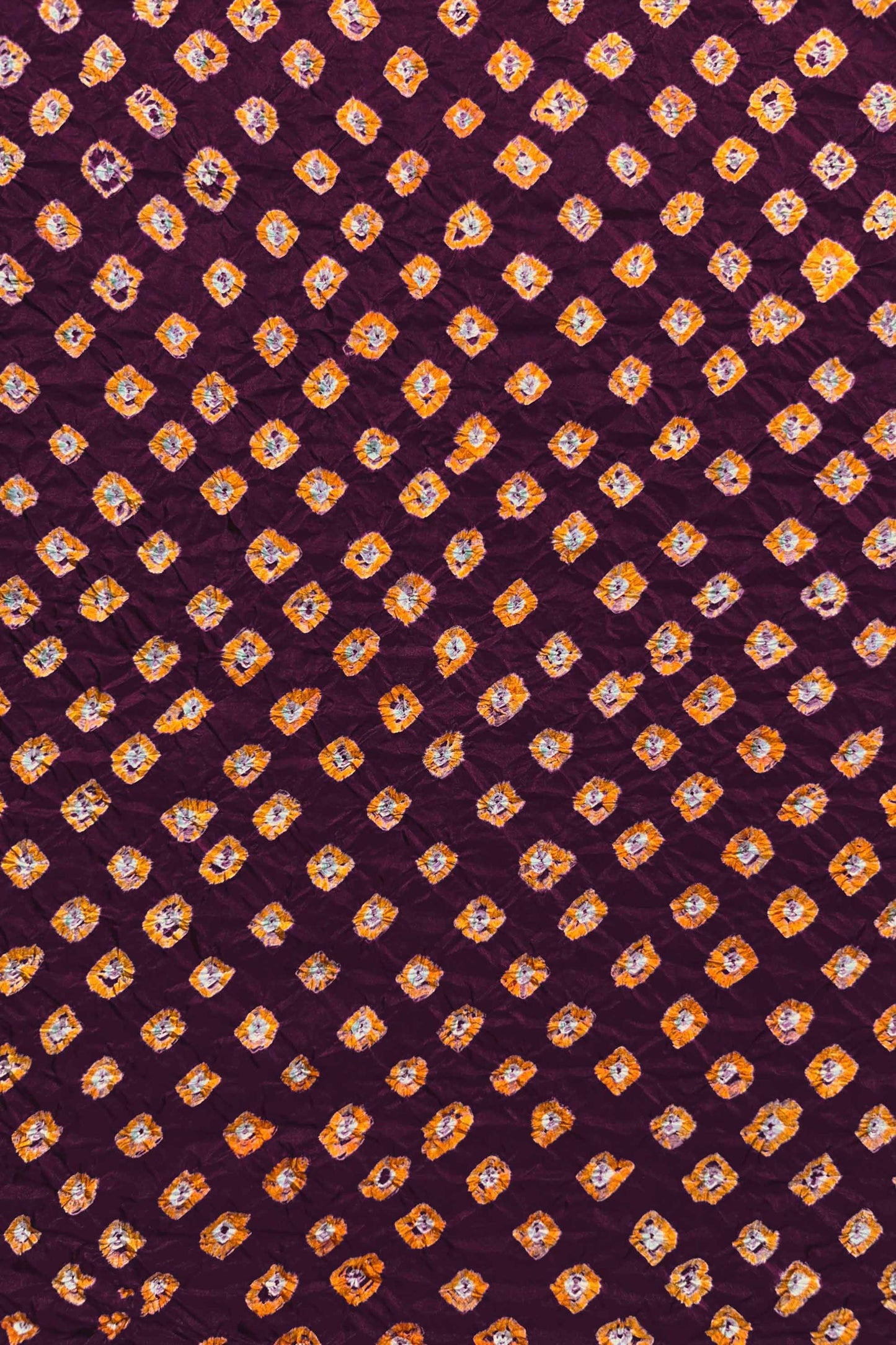 Maroon Mulberry silk fabric showcasing dual colour Yellow bandhani patterns and Chakor brand watermark.
