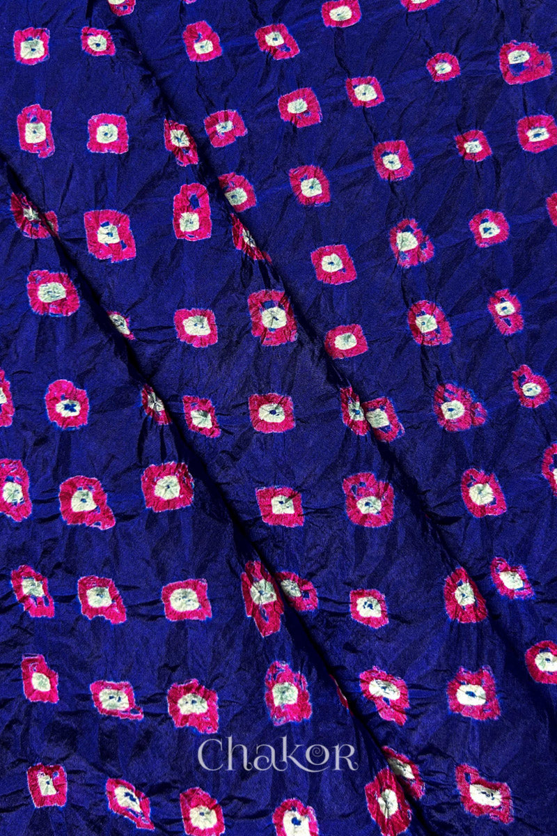 Navy Mulberry silk fabric showcasing dual colour Pink bandhani patterns with folds and Chakor brand watermark.
