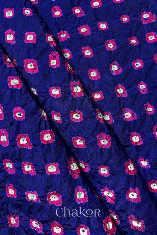 Navy Mulberry silk fabric showcasing dual colour Pink bandhani patterns with folds and Chakor brand watermark.
