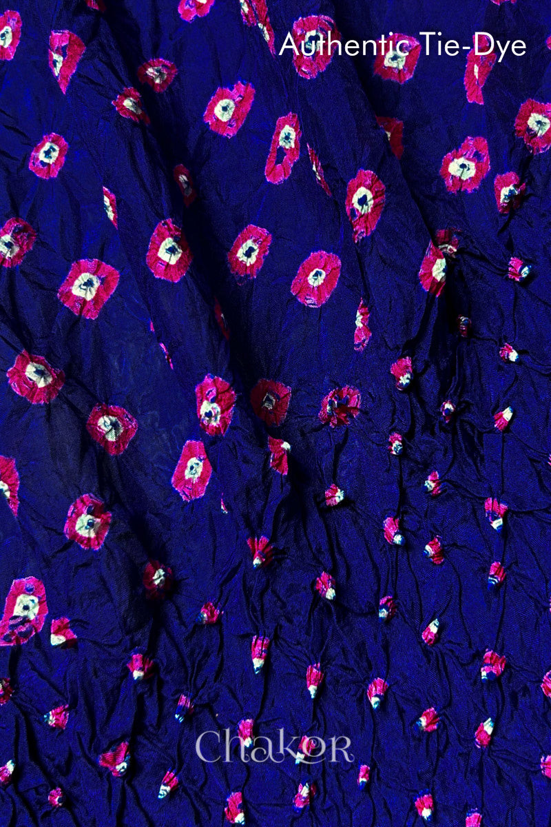 Close-up of Navy mulberry silk fabric with Pink and white patterns, featuring texture of authentic bandhani patterns.
