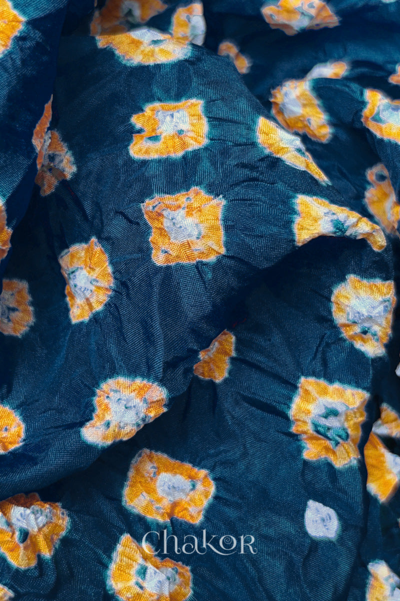 Close-up of Deep Indigo fabric with Yellow and white bandhani patterns, featuring texture and sheen of soft mulberry silk fabric.
