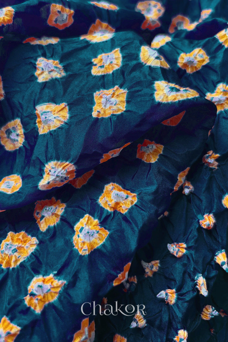 Close-up of Deep Indigo fabric with Yellow and white bandhani patterns, featuring texture and sheen of soft mulberry silk fabric.

