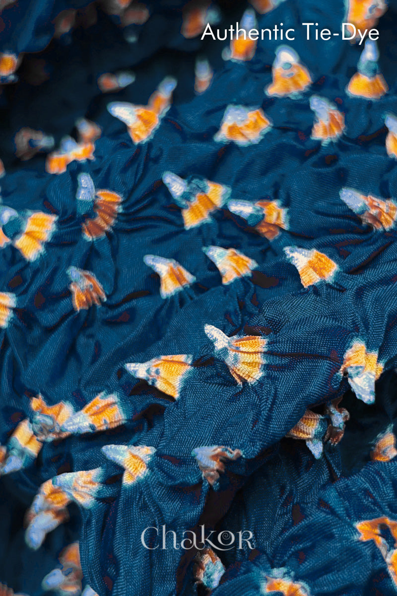 Close-up of Deep Indigo mulberry silk fabric with Yellow and white patterns, featuring texture of authentic bandhani patterns.
