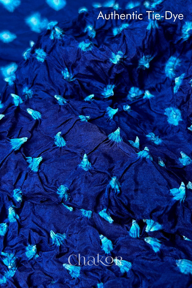 Close-up of Navy mulberry silk fabric with Turquoise Blue and white patterns, featuring texture of authentic bandhani patterns.
