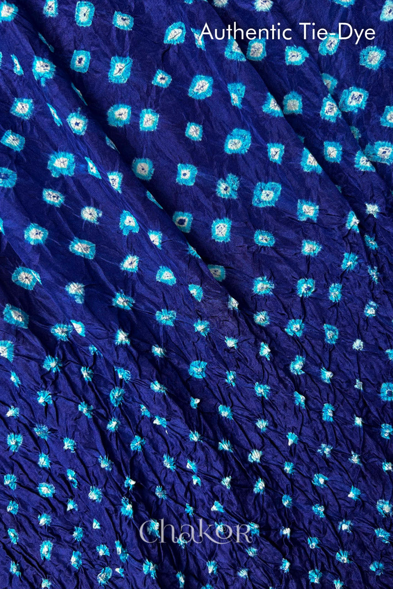 Close-up of Navy mulberry silk fabric with Turquoise Blue and white patterns, featuring texture of authentic bandhani patterns.
