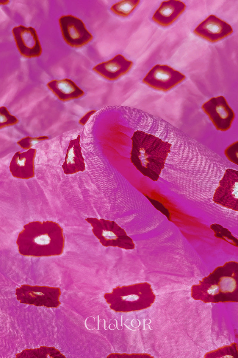 Close-up of Light Pink fabric with Pink and white bandhani patterns, featuring texture and sheen of soft mulberry silk fabric.

