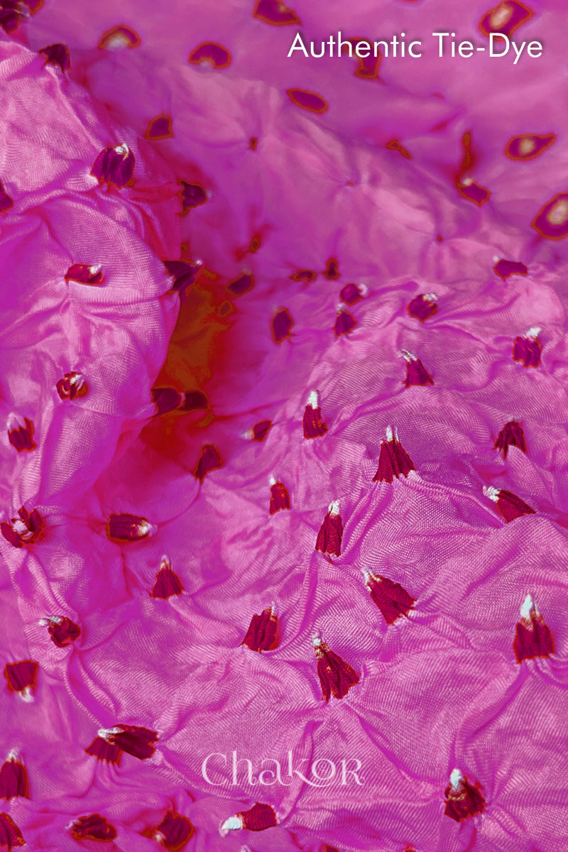 Close-up of Light Pink mulberry silk fabric with Pink and white patterns, featuring texture of authentic bandhani patterns.
