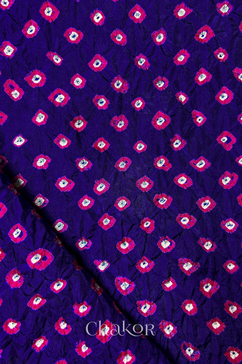 Purple Mulberry silk fabric showcasing dual colour Pink bandhani patterns with folded corner and Chakor brand watermark.
