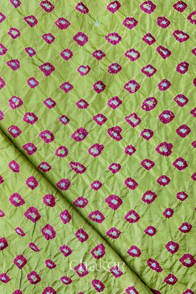 Pista Green Mulberry silk fabric showcasing dual colour Pink bandhani patterns with folded corner and Chakor brand watermark.
