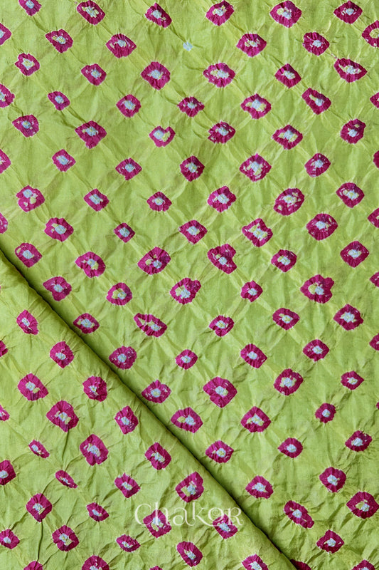 Pista Green Mulberry silk fabric showcasing dual colour Pink bandhani patterns with folded corner and Chakor brand watermark.
