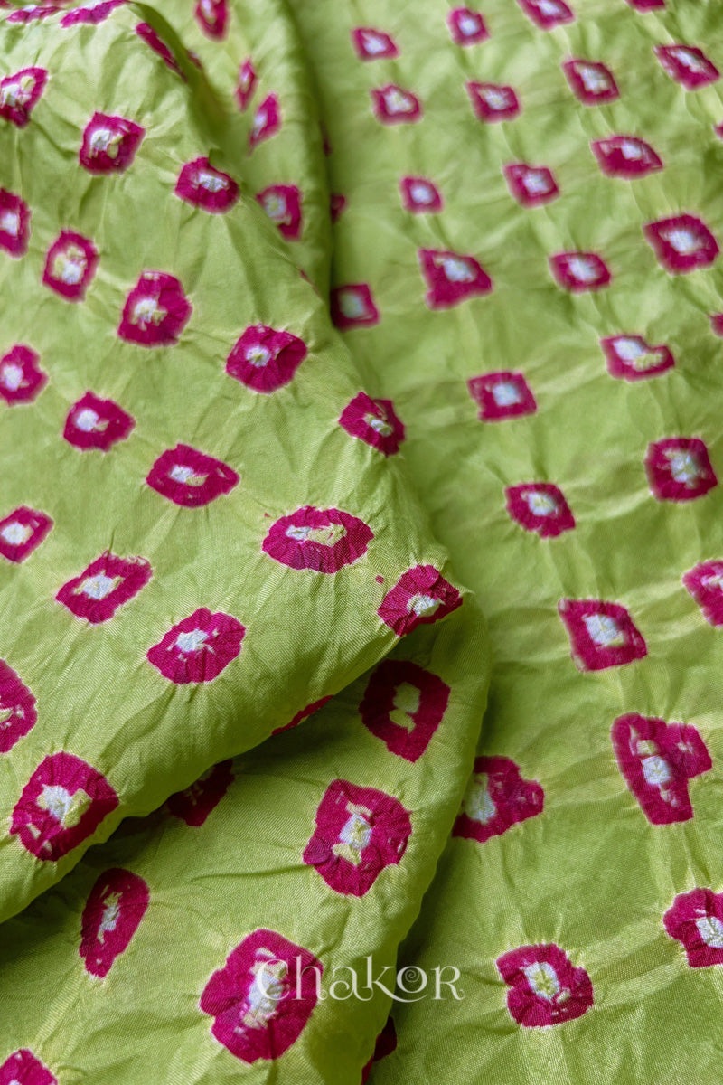 Pista Green Mulberry silk fabric showcasing dual colour Pink bandhani patterns with folded corner and Chakor brand watermark.
