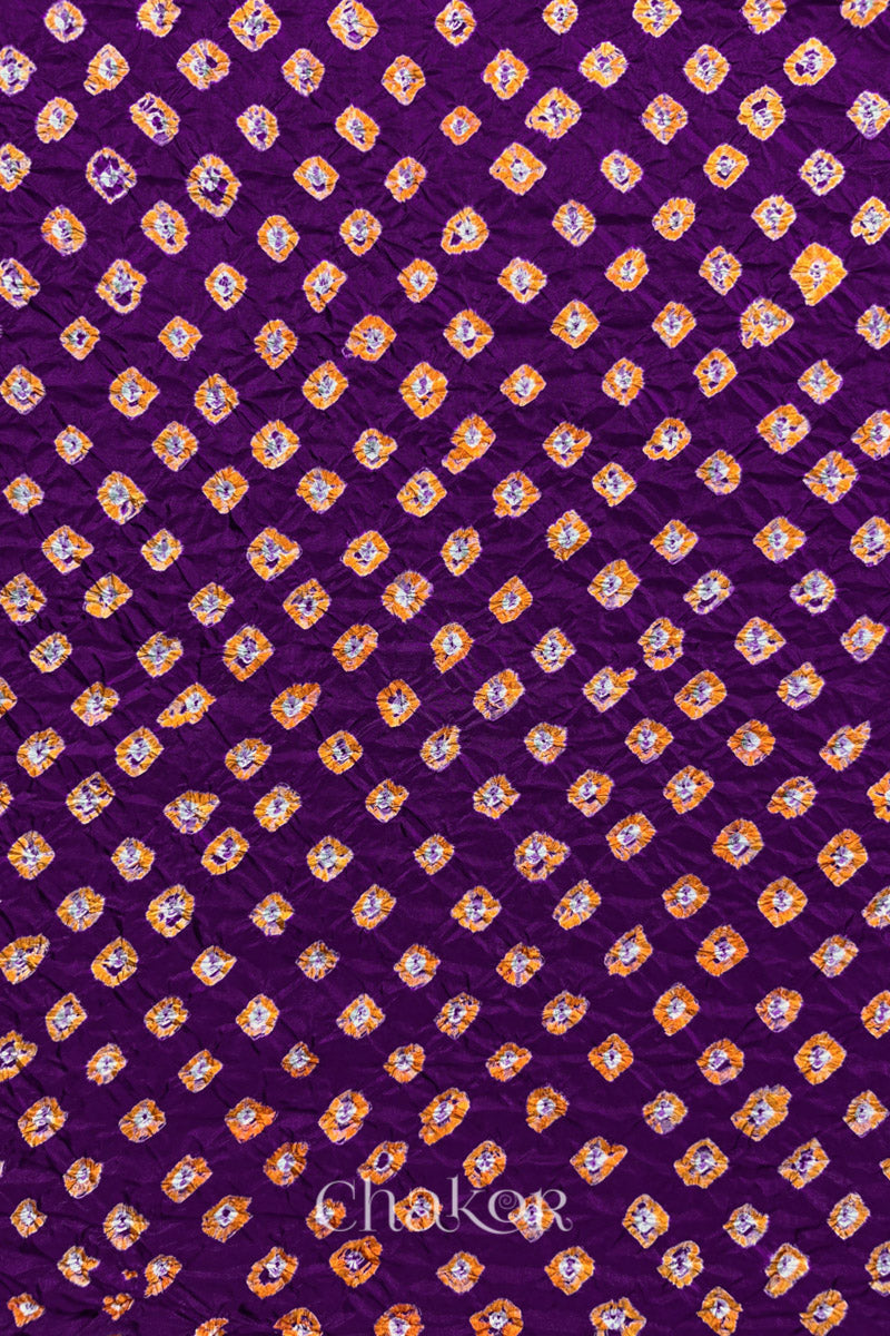 Purple Mulberry silk fabric showcasing dual colour Yellow bandhani patterns and Chakor brand watermark.
