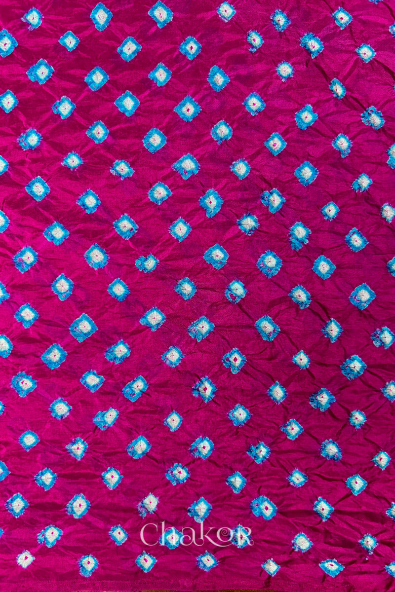 Rani Pink Mulberry silk fabric showcasing dual colour Turquoise Blue bandhani patterns and Chakor brand watermark.
