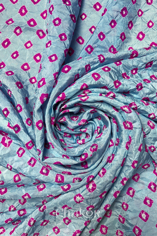 Sky Blue Mulberry silk fabric with dual colour Pink bandhani dots, arranged in a swirling design  & Chakor brand watermark.
