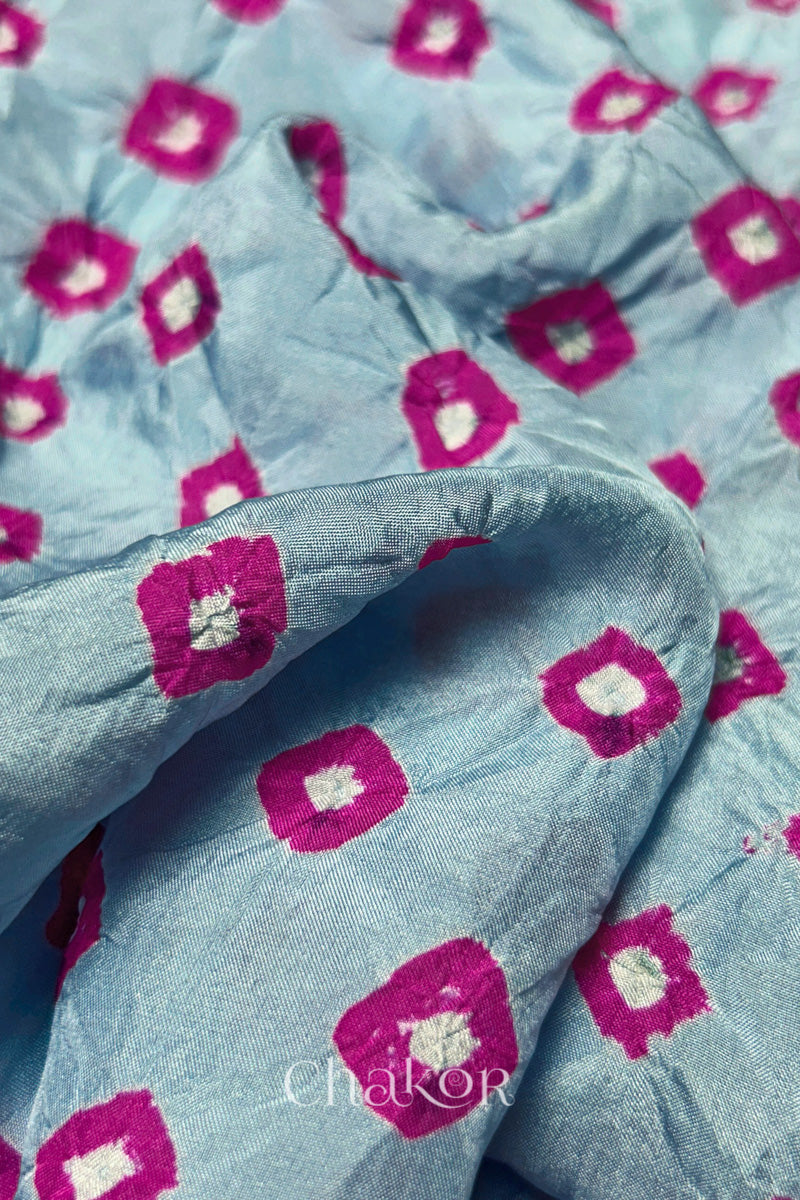 Close-up of Sky Blue fabric with Pink and white bandhani patterns, featuring texture and sheen of soft mulberry silk fabric.
