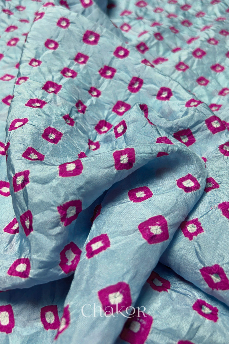 Close-up of Sky Blue fabric with Pink and white bandhani patterns, featuring texture and sheen of soft mulberry silk fabric.
