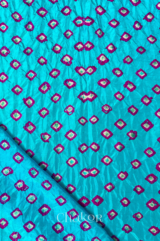 Turquoise Blue Mulberry silk fabric showcasing dual colouPink bandhani patterns with folded corner and Chakor brand watermark.
