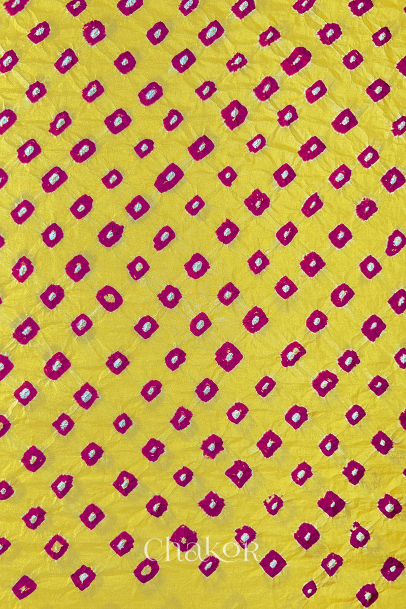 Yellow Pink Mulberry silk fabric showcasing dual colouPink bandhani patterns and Chakor brand watermark.
