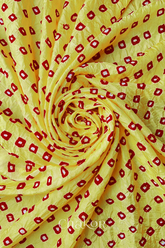 Yellow Red Mulberry silk fabric with dual coloured bandhani dots, arranged in a swirling design  & Chakor brand watermark.