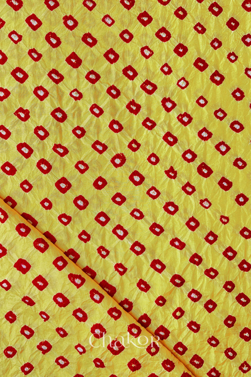Yellow Red Mulberry silk fabric showcasing dual coloured bandhani patterns with folded corner and Chakor brand watermark.