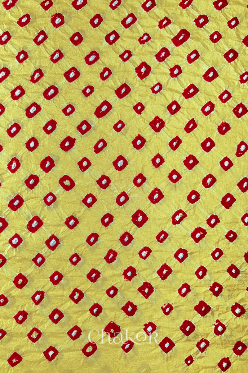 Yellow Red Mulberry silk fabric showcasing dual coloured bandhani patterns and Chakor brand watermark.